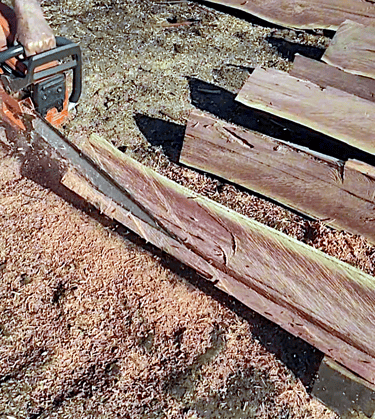 Facing fence post with chainsaw
