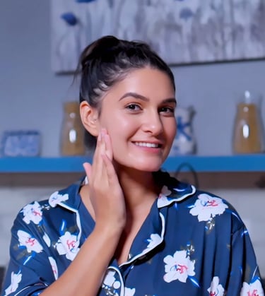 a woman touching her face in a blue shirt 