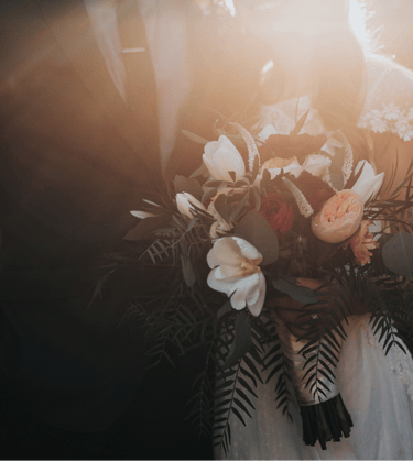 a bride and groom holding a bouquet of flowers