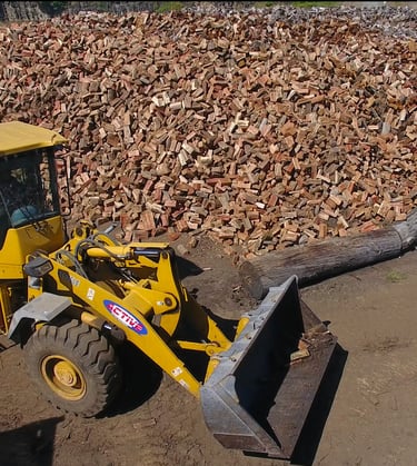 Loader in front of seasoned firewood