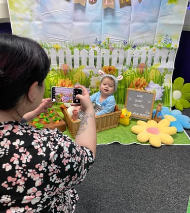 Little girl in bunny ears, in front of easter backdrop