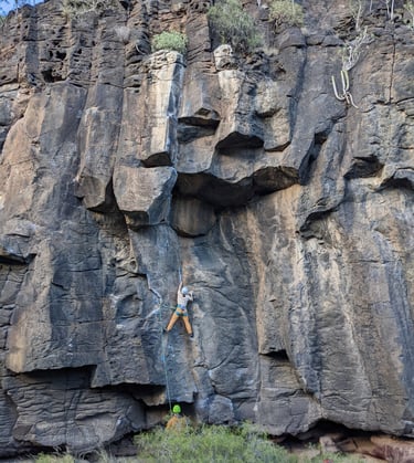a lead person climbing on rocks