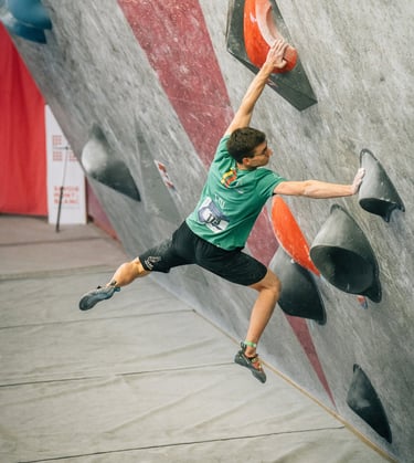 a man bouldering on a climbing wall
