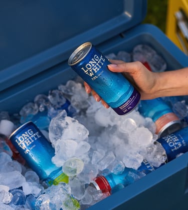 Product photography - a person holding a can of long white over an ice bucket