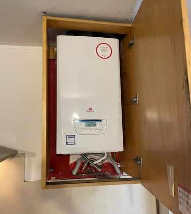 a white tankless water heater with a red and white sign