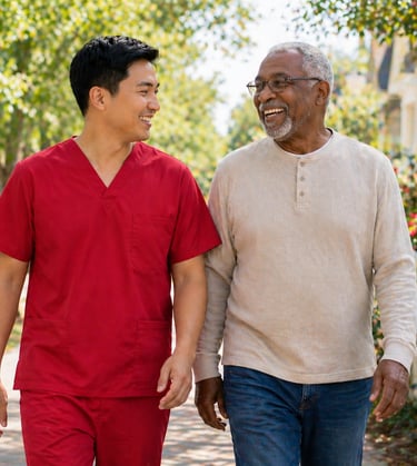 Caregiver in red scrubs walking with senior outdoors, sharing conversation, companionship, and connection in a calm setting