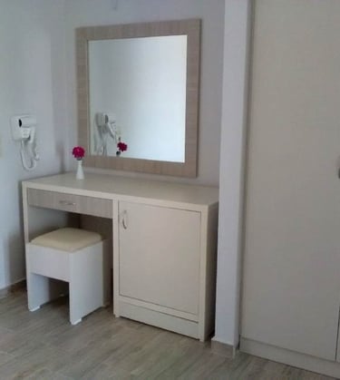 a white vanity with a mirror and a mirror