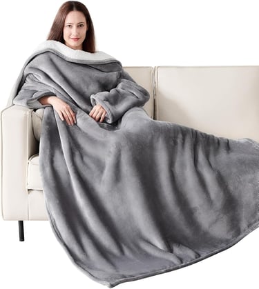 a woman sitting on a couch with a blanket on it