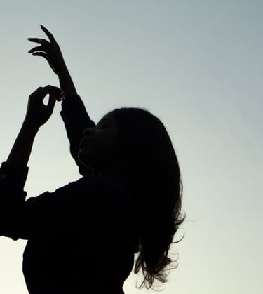 Photograph of a lady elegantly placing her arms up in the sky