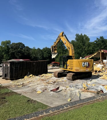 Excavator loading materials on a residential demolition site