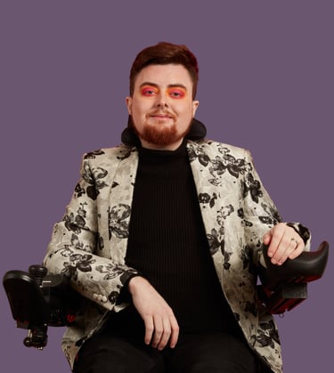 Jamie Hale, a white electric wheelchair user wearing a silver floral jacket