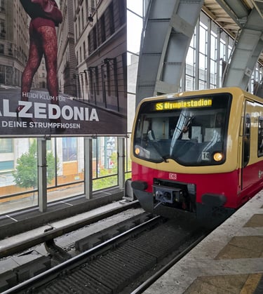 a train is parked in front of a large poster
