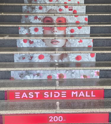 a large poster of a woman's face on a staircase case