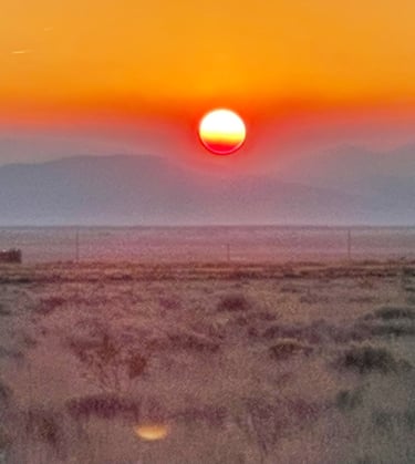 a sunset with a red sun setting in the background