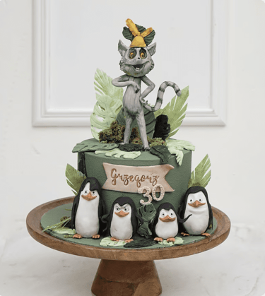 a cake with a cat and penguins on it