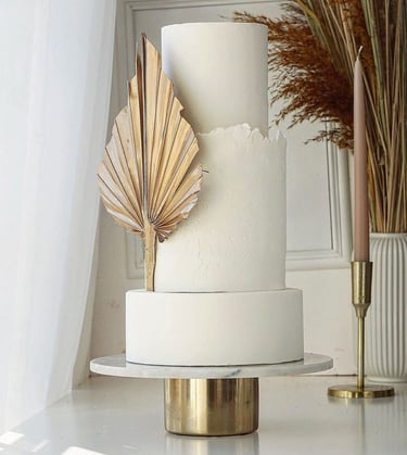 a white cake with a gold leaf decoration