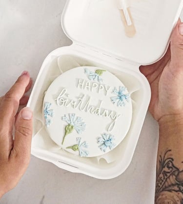 a person holding a cake with a happy birthday cake