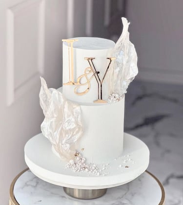 a white cake with a gold and silver cake topperf