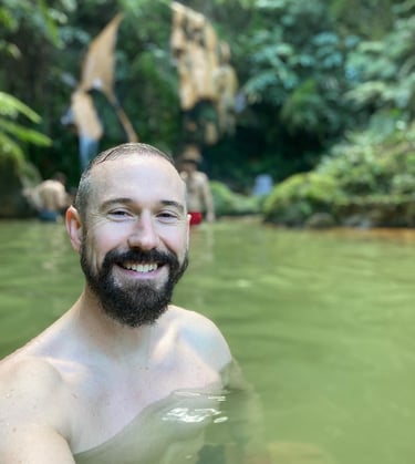 a middle aged man happy in a volcanic heated pool in azores