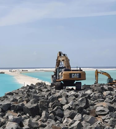 a construction worker is working on a beach with rock boulder's by swastika exim team in Maldives