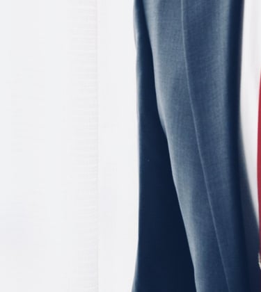 Um homem vestindo terno e gravata segurando um celular nas mãos