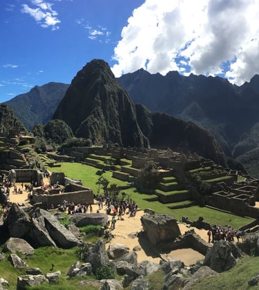 Panorama du Machu Picchu sous un ciel bleu éclatant, les terrasses incas et les ruines baignées de l