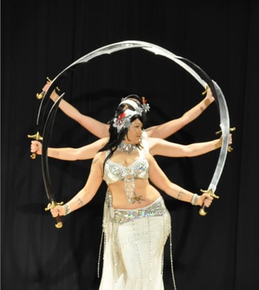 Shahravar and troupe Habibi Habibi of SLC dancing with double scimitars wearing white costumes