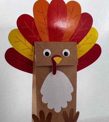 A craft class of a brown paper bag made into a turkey