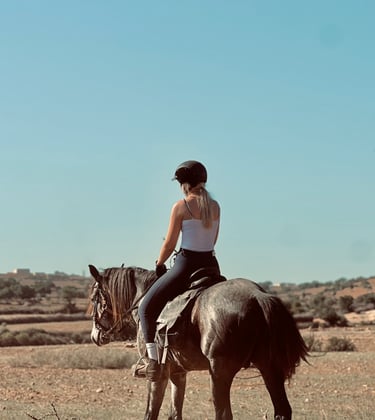 femme montant un cheval dans la campagne, avec un beau ciel bleu