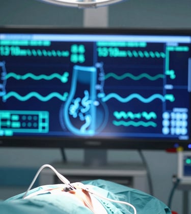 A close-up of a virtual medical simulation showing a realistic surgical theater environment with holographic vital sign displays in cyan and navy blue, set in a North American hospital context.