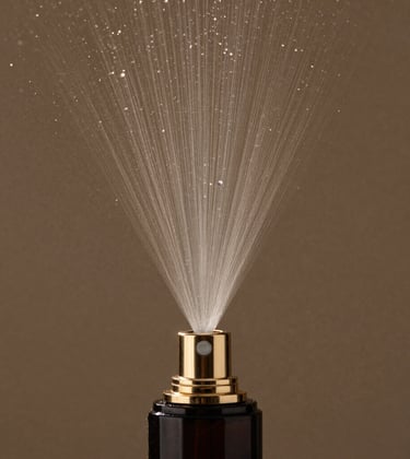 A macro photograph focusing on the fine spray of a luxury atomizer, the tiny droplets suspended in the air against a muted bronze background. The lighting is focused and controlled, emphasizing the concept of diffusion and lasting impact.