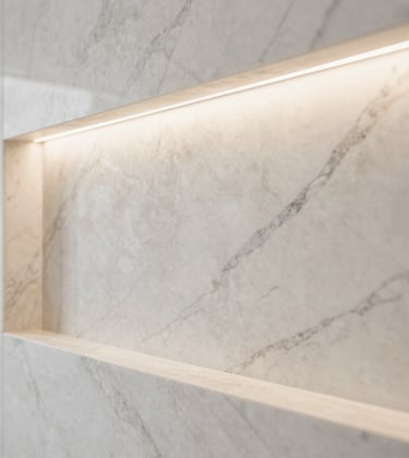 A detail shot of high-end finishing work, showing a perfectly installed marble wall panel with recessed lighting, in a palette of creamy off-white and soft stone grey.