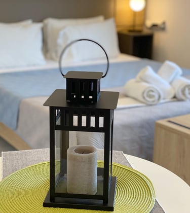 a lantern light up in a bedroom with a bed and a table