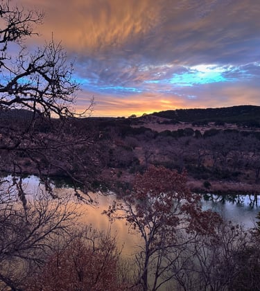 Sunset over river, in mountain terrain.