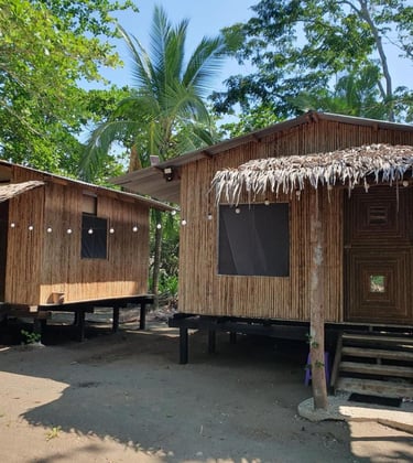 wooden cabins against trees and blue skies on the carribean coast in costa rice at camping babsita
