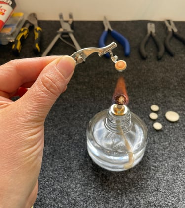 gros plan sur une main chauffant un piston de flûte traversière pour le réparer