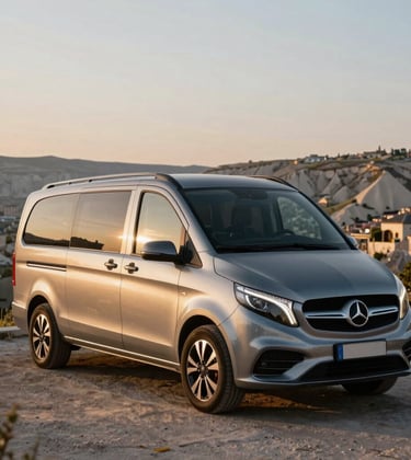 A luxury modern tour van parked at a scenic viewpoint overlooking a historic Middle Eastern / Turkish landscape during golden hour.