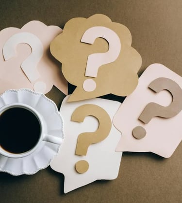 a cup of coffee and question mark mark on a table