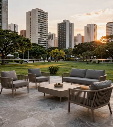 A spacious terrace of a high-end apartment in a South American / Brazilian city, featuring designer outdoor furniture in taupe and slate grey, overlooking a lush park, sunset lighting.