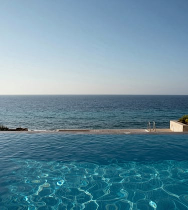 An elegant infinity pool on a private terrace in Netanya, merging visually with the blue waters of the Mediterranean Sea under a clear sky.