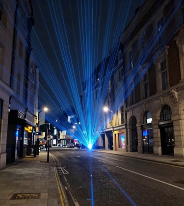 LiDAR laser scanning point cloud of a modern European / British city street at night, abstract digital data streams in electric blue and dark charcoal, industrial tech style.