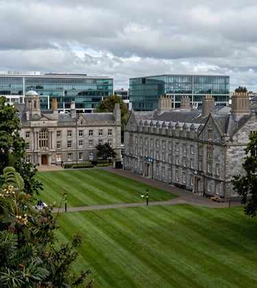 A photography shot of a lush green university campus in Dublin, Ireland. The scene features historic stone architecture blended with modern glass facilities, representing academic excellence in a North American / US corporate photographic style.