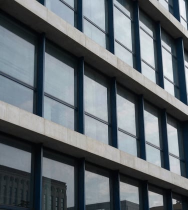 A sophisticated photograph of an architectural detail in a modern steel and glass building, with tones of dark navy blue and off-white, reflecting institutional stability.