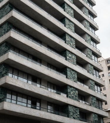 Modern architectural facade of a luxury residential building in the Itaim Bibi district of São Paulo. The design incorporates dark green stone cladding and white concrete. South American / Brazilian metropolis background, sharp architectural detail, daylight photography.