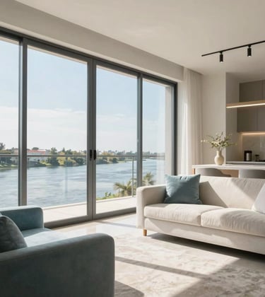 A modern, bright apartment interior in Rosario with floor-to-ceiling windows overlooking the Paraná river. Sophisticated furniture in light blue and off-white tones, reflecting professional real estate photography and a sense of inviting comfort.