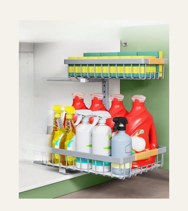 Two-tier pull-out metal cabinet organizer filled with cleaning spray bottles, detergent, and sponges.