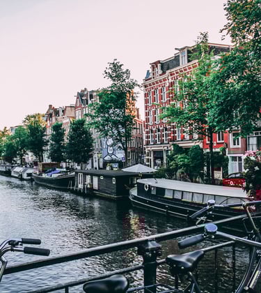 bicycles parked on a bridge over a river in Amsterdam