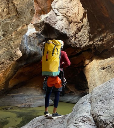 a person with a backpack on a rock formation