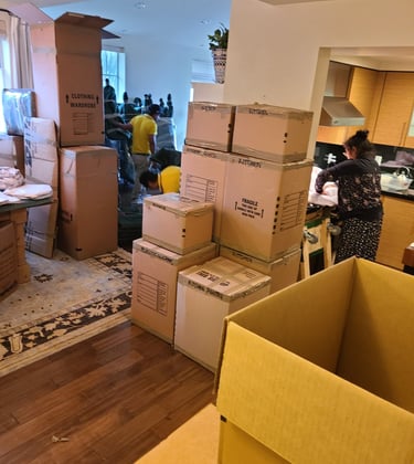Professional movers packing cardboard boxes during a residential house relocation service.