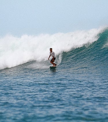a man riding a surfboard on a wave
